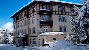 Ein großes, mehrstöckiges Gebäude im traditionellen Baustil, mit einem markanten Balkon und Rundbogenfenstern.