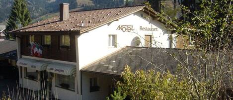 A two-story building with a sign indicating it is a motel and restaurant.