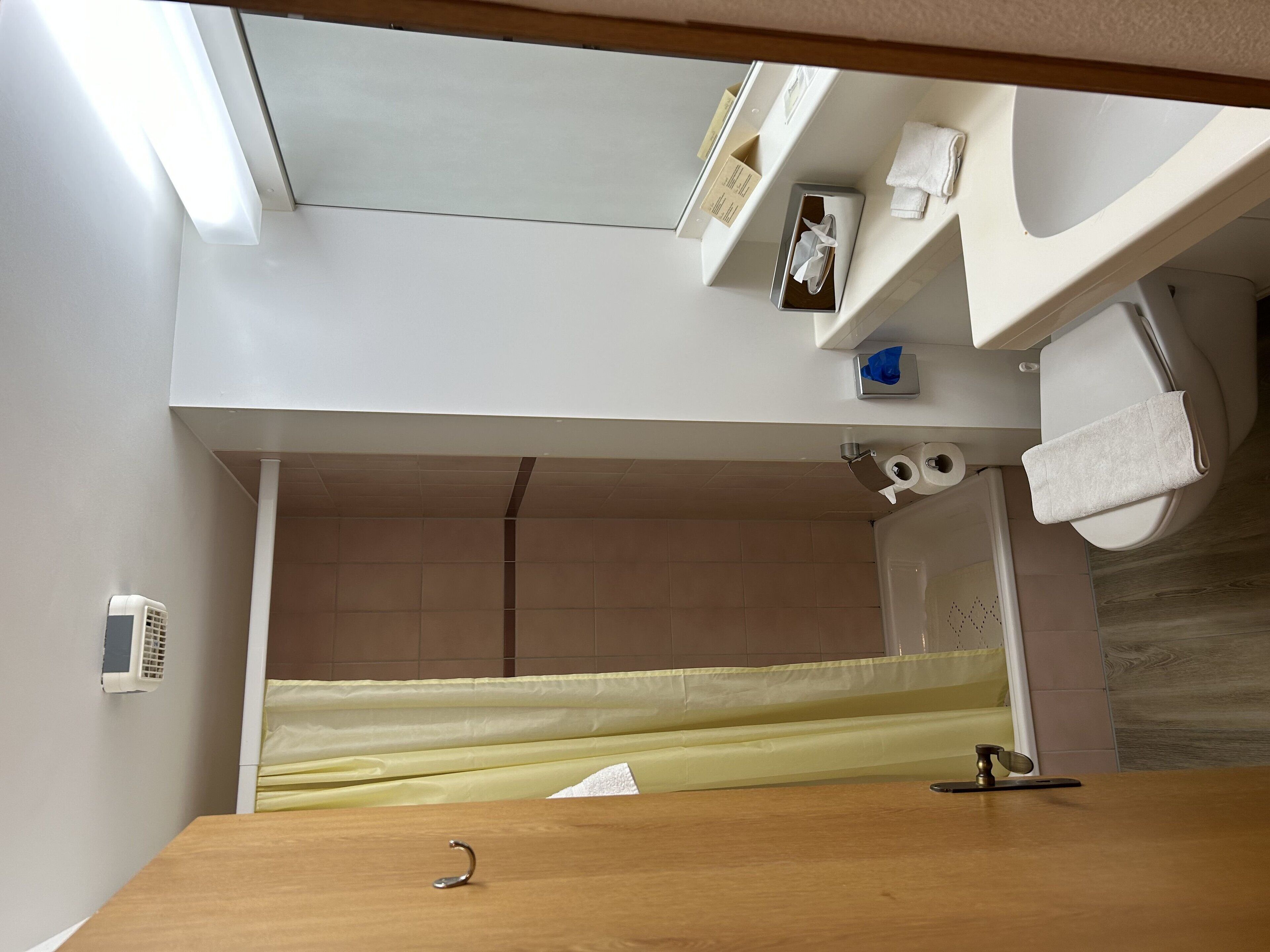 Une salle de bain avec un meuble-lavabo en bois, des toilettes, un lavabo et une baignoire.