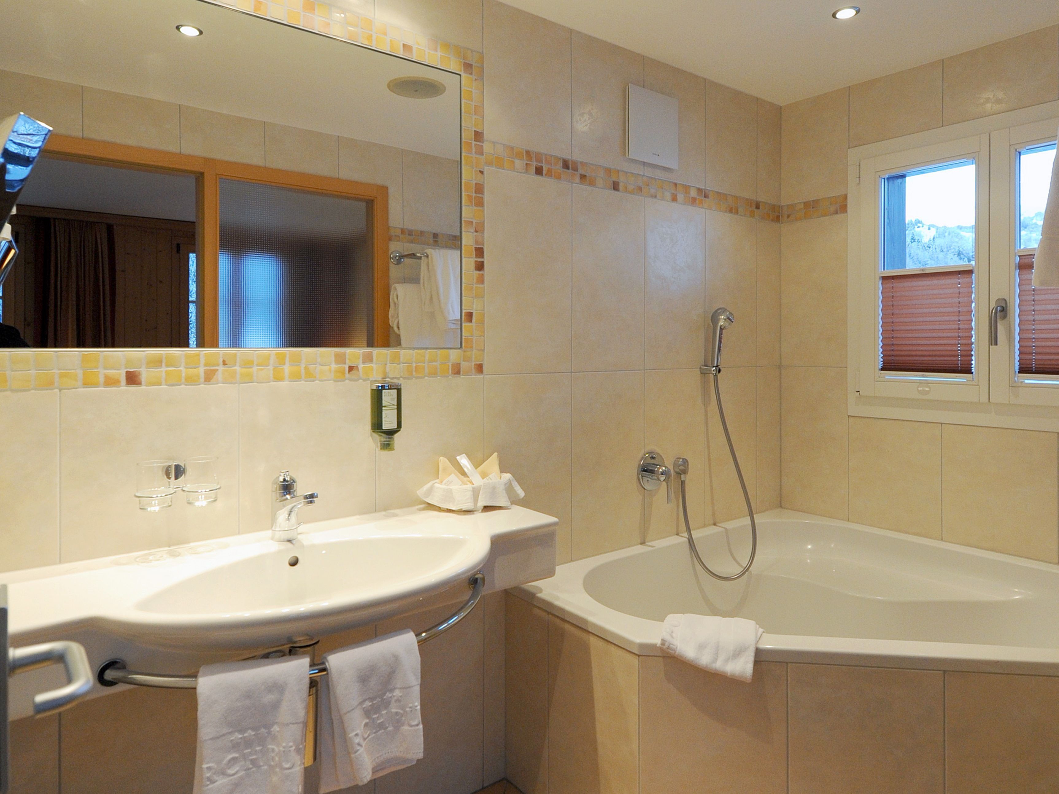 A bathroom with a sink, mirror, shower, and bathtub.