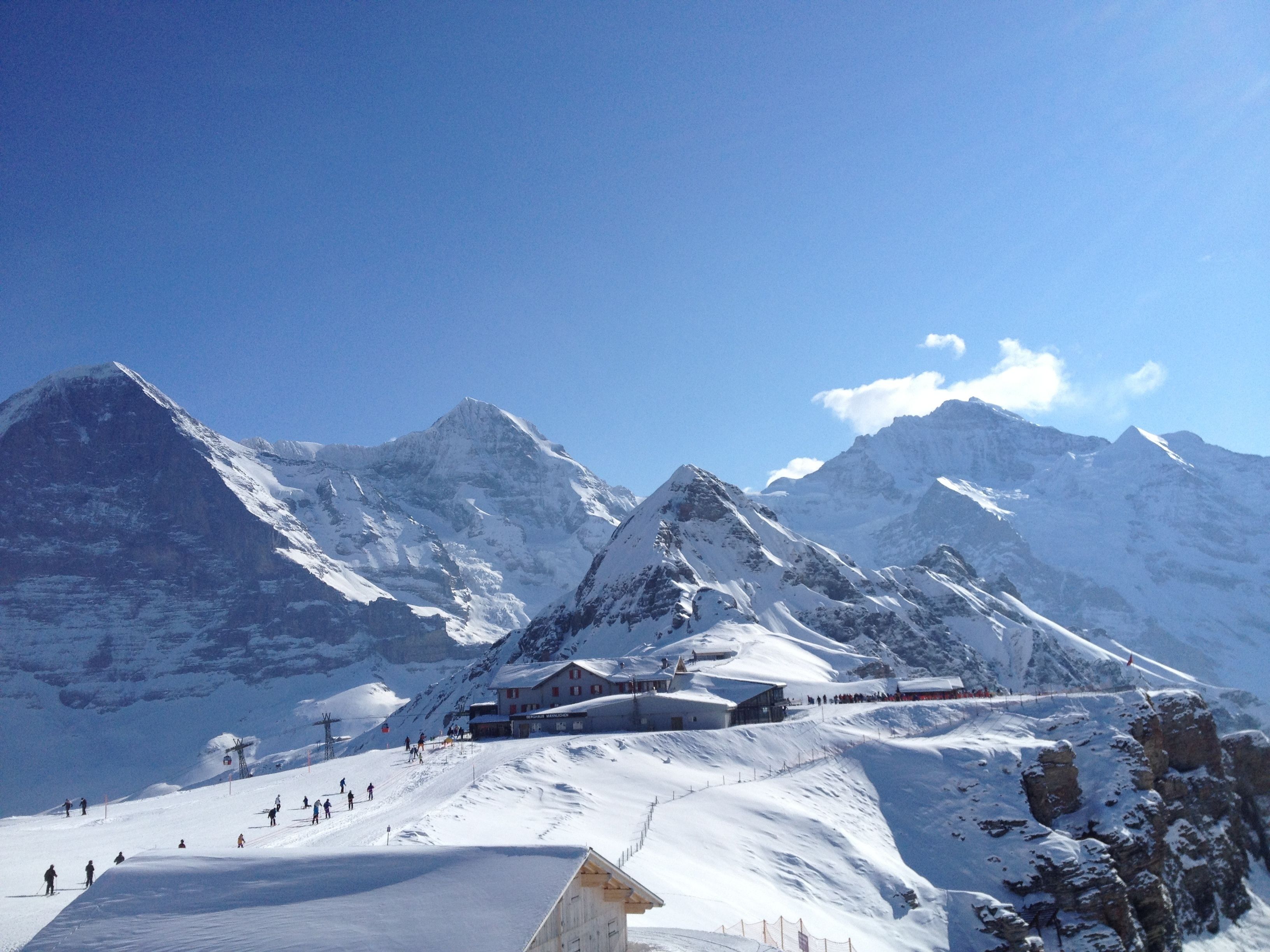 Une montagne enneigée abritant une station de ski, avec des bâtiments et des pistes de ski.