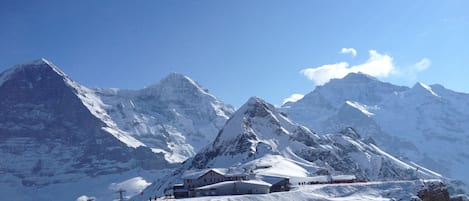 Une montagne enneigée abritant une station de ski, avec des bâtiments et des pistes de ski.