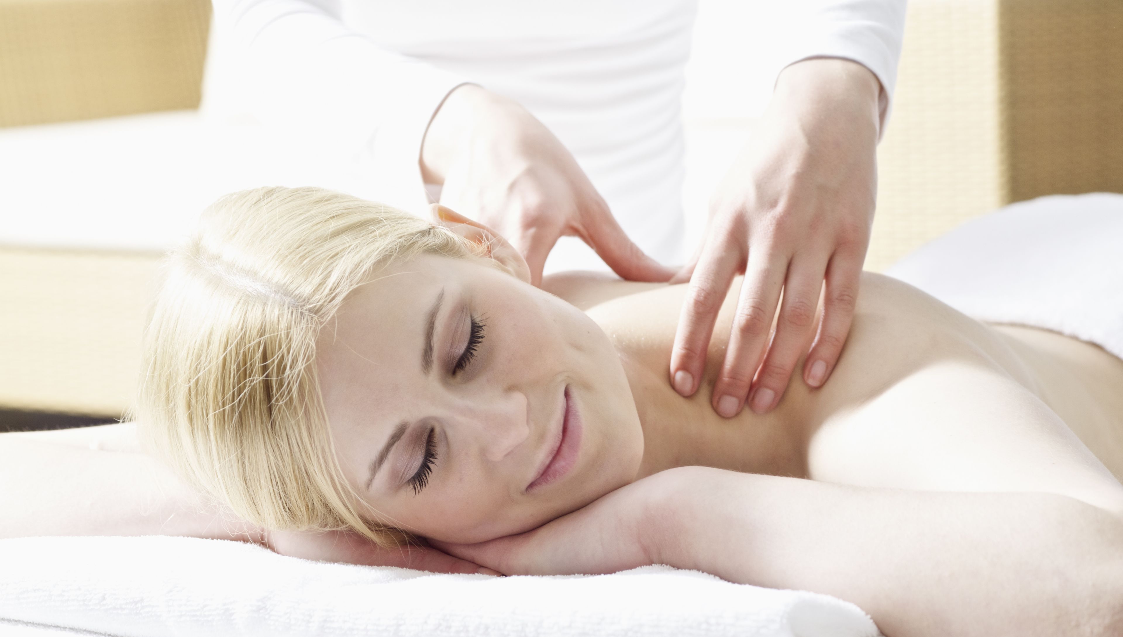 A person receiving a massage on a white towel.