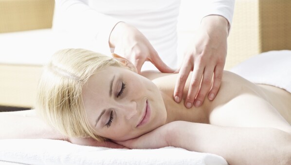 A person receiving a massage on a white towel.
