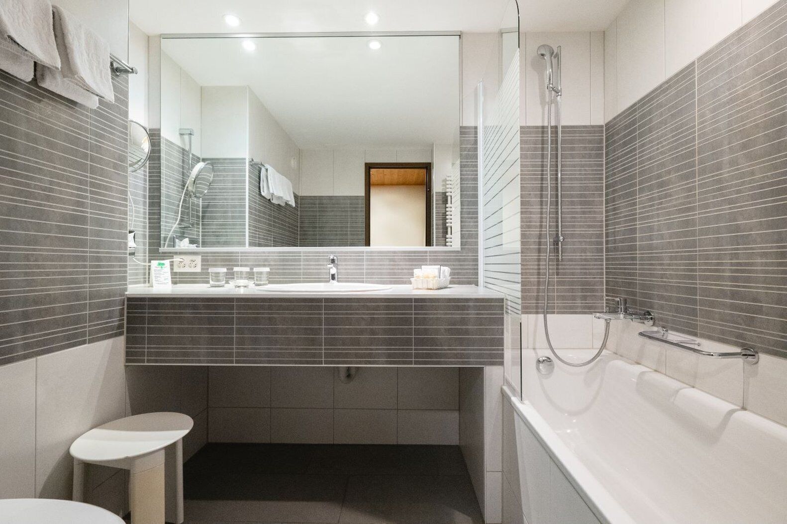 Une salle de bain moderne équipée d’une douche, de toilettes et d’un lavabo.