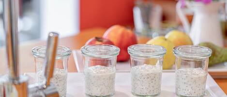 Four glass jars with a white creamy substance on a white tray.