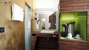 A modern bathroom with a wooden vanity, a sink, and a mirror.