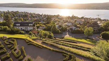 A residential area with a lake, houses, and a well-maintained garden.