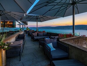 An outdoor seating area with umbrellas, sofas, and potted plants. - Hotel Belvoir Lake View & Spa (Rüschlikon)