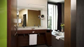 Une salle de bain moderne avec un meuble-lavabo en bois, deux vasques, un grand miroir et une fenêtre avec des rideaux.
