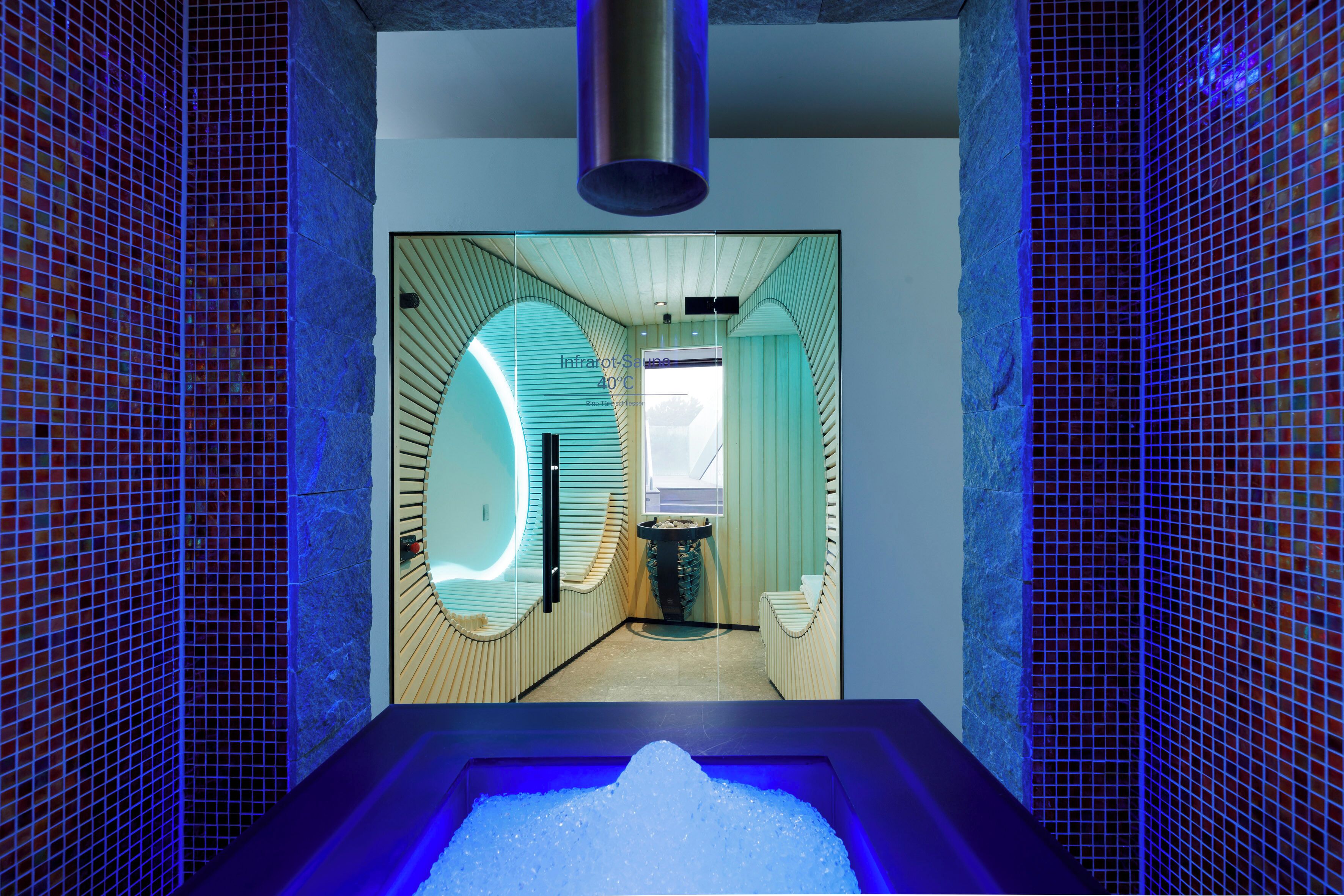 A spa area with a hot tub, a massage chair, and a stone wall.