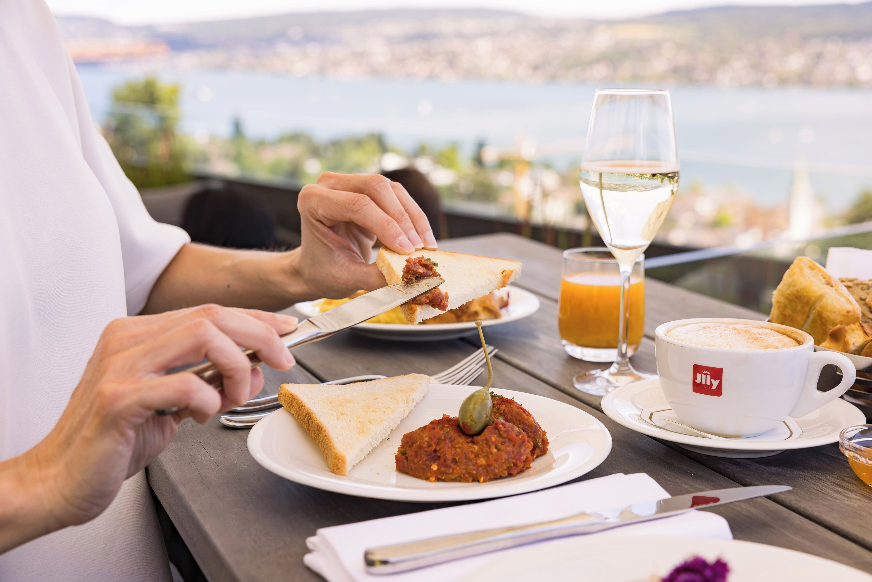 Une table à manger avec une assiette de nourriture, un verre de jus de fruits et une tasse de café.