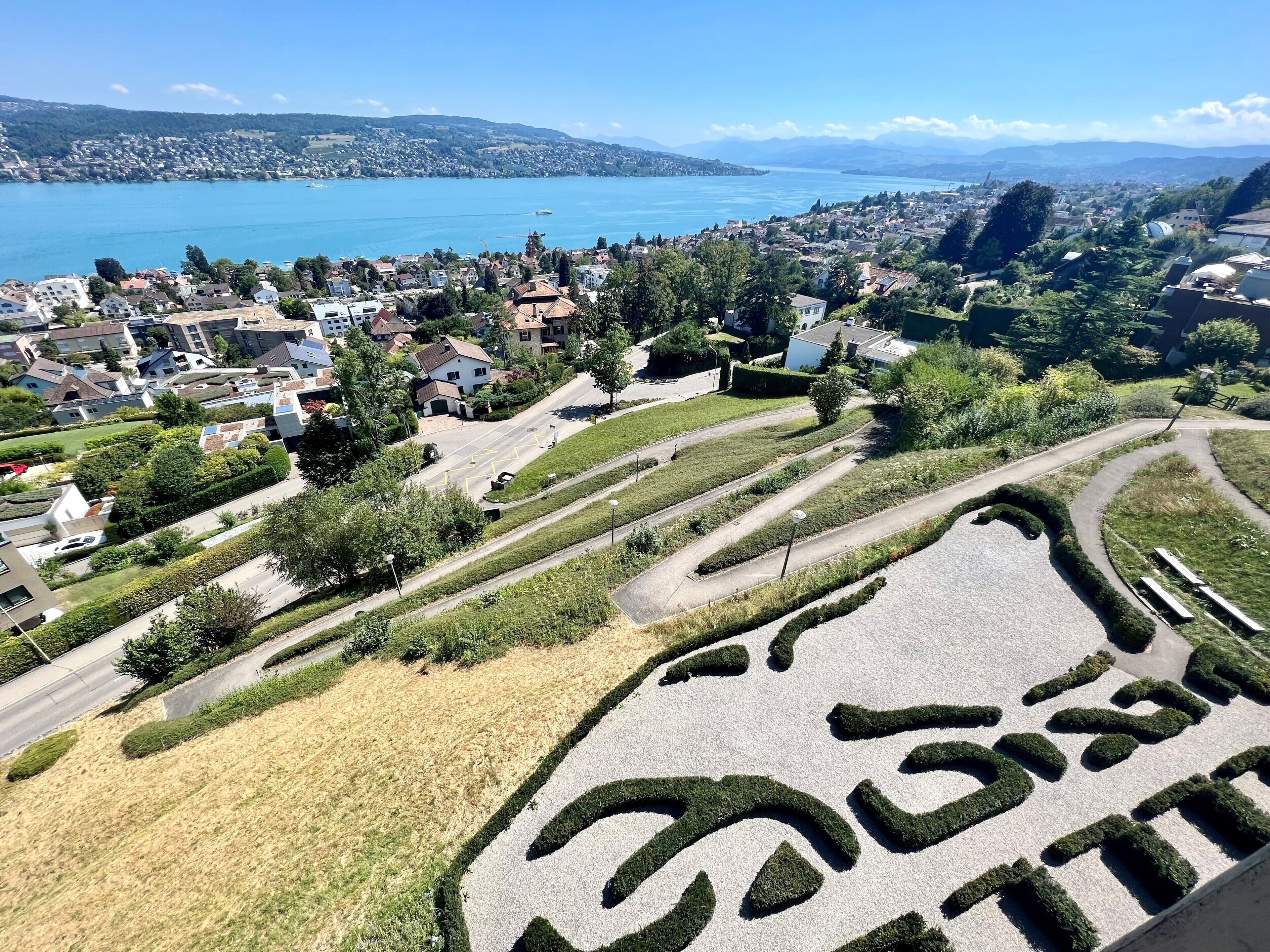 Zona residencial con vista despejada a un lago, casas y un camino sinuoso.