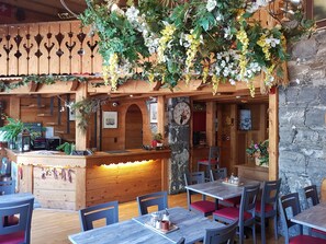 A rustic wooden interior with a reception desk, seating area, and decorative plants. - Hotel De Geneve (Geneva)