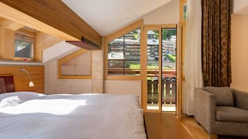 Quarto com cama, mesa de cabeceira, luminária, janela com vista para edifícios e porta deslizante para uma varanda.