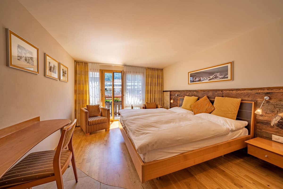 A modern bedroom with a wooden bed, a desk, and a chair.