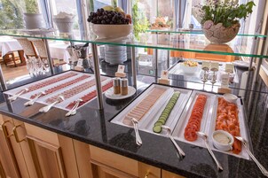 A buffet with various food items and utensils.