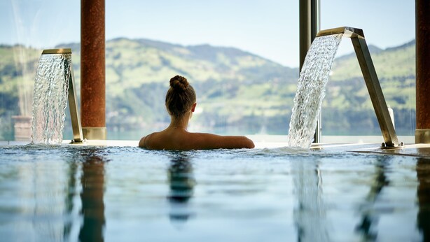 A person in a hot tub with water jets, overlooking a mountainous landscape. - Belvédère Strandhotel (Spiez)