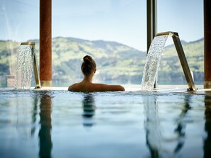 A person in a hot tub with water jets, overlooking a mountainous landscape. - Belvédère Strandhotel (Spiez)