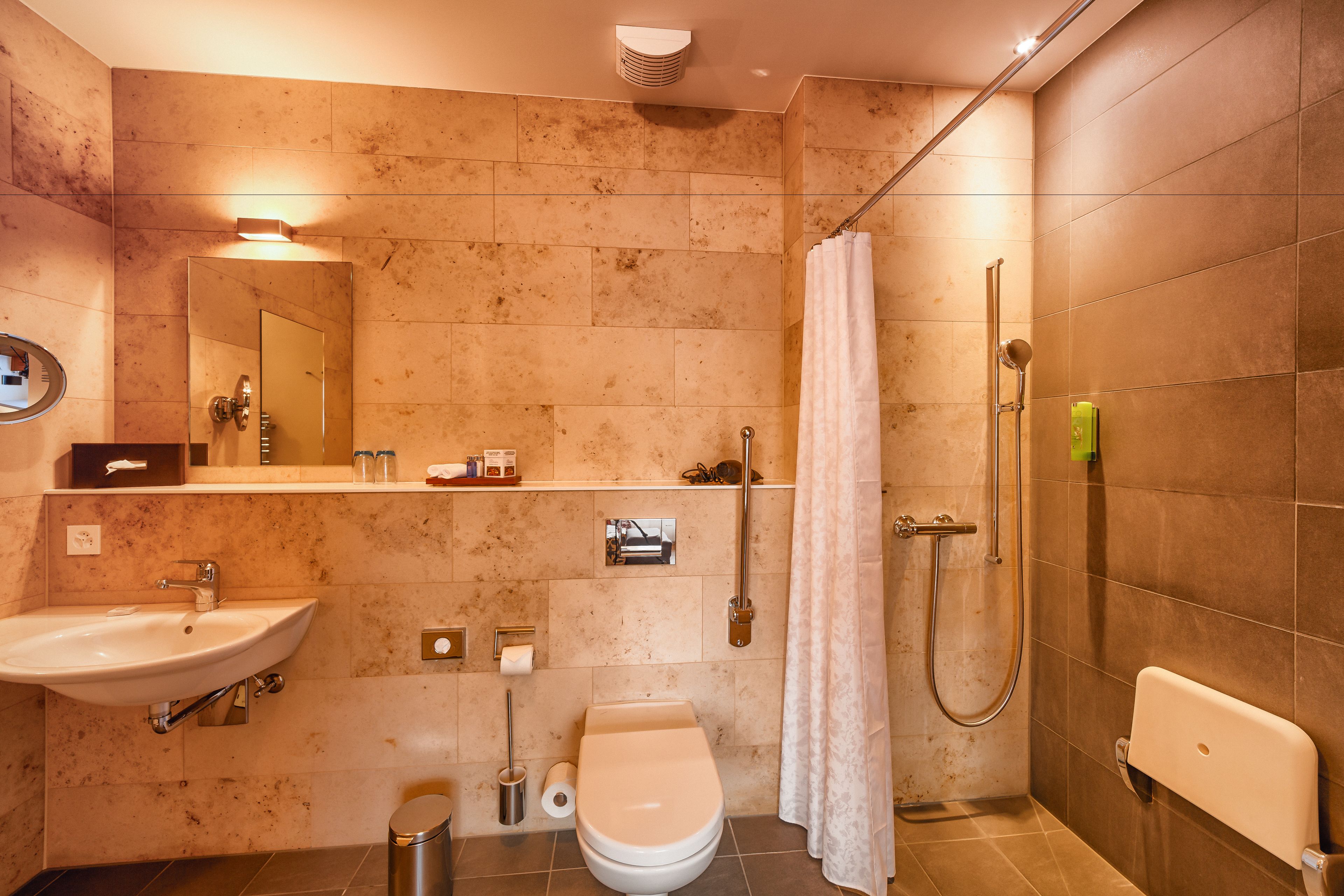 A modern bathroom with a sink, toilet, and shower.