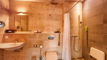 Une salle de bain moderne équipée d’un lavabo, de toilettes et d’une douche.