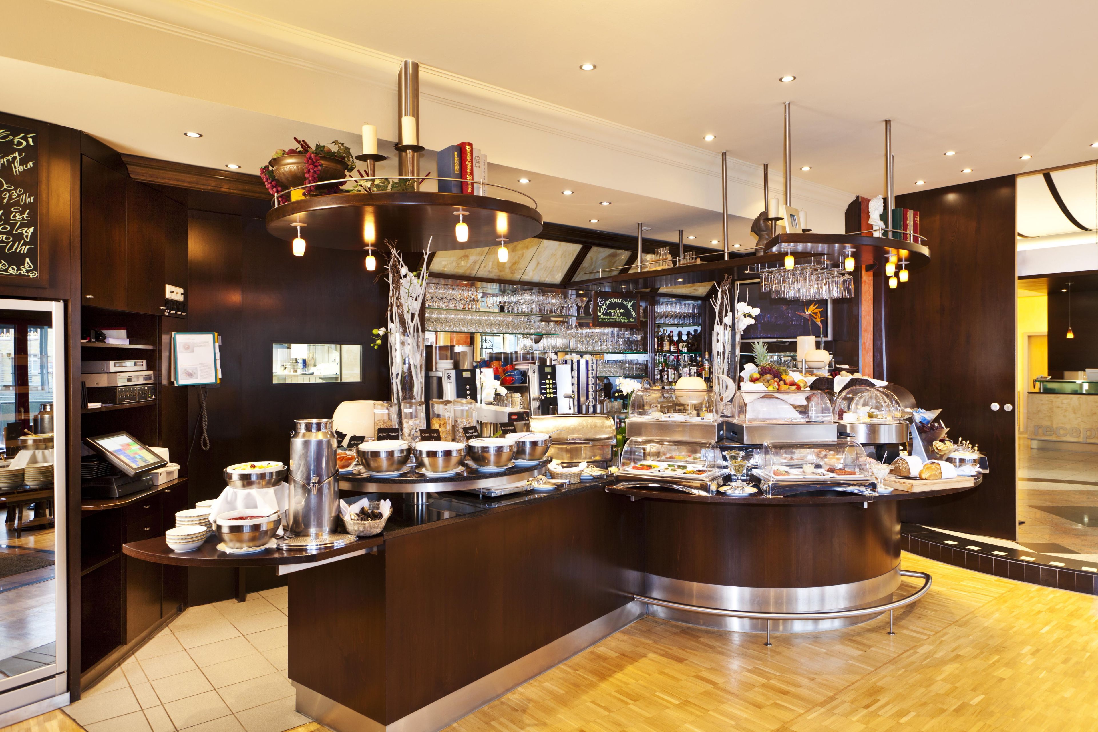 A buffet area with a variety of food options, a coffee station, and a bar with a wine selection.