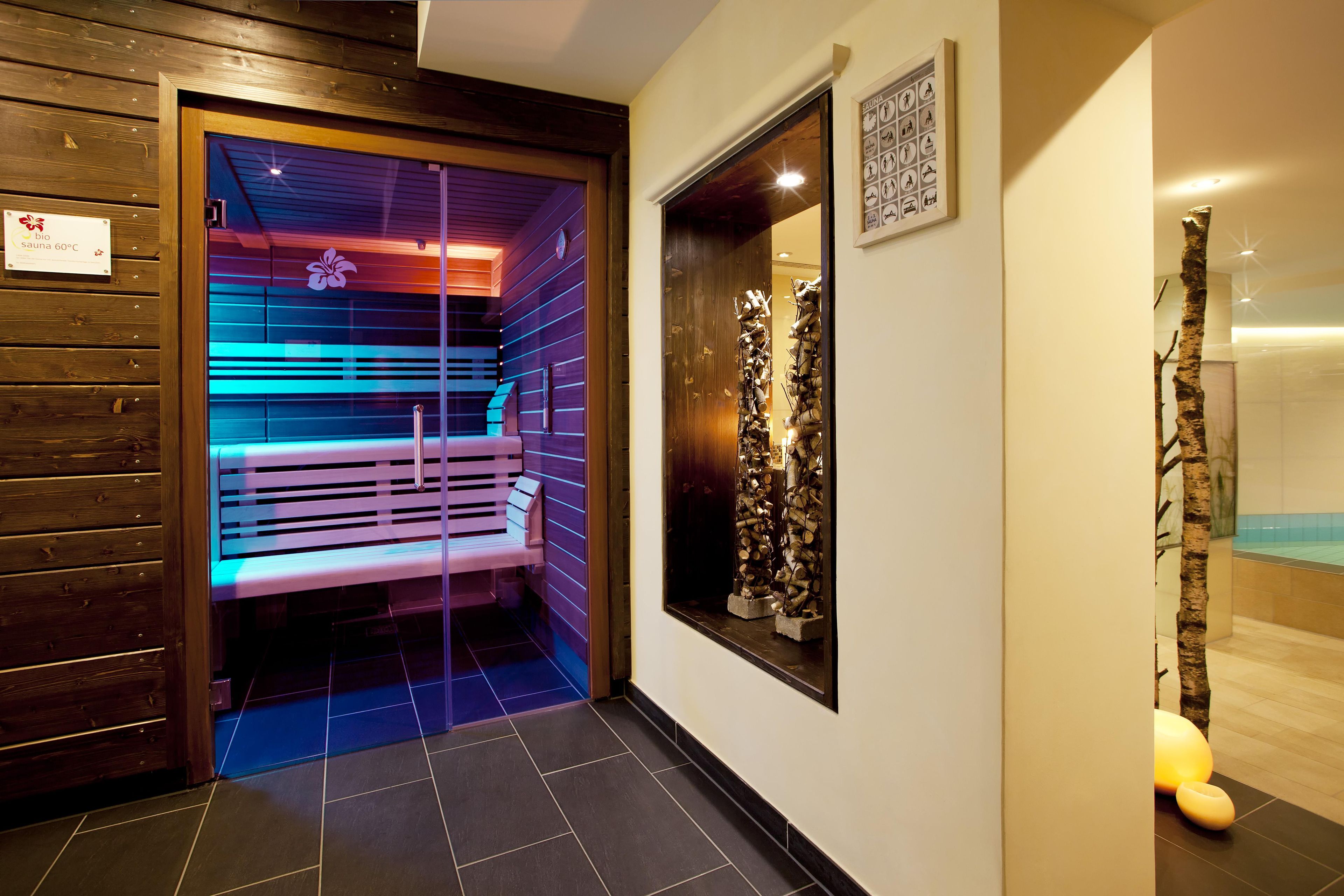 A sauna room with a bench, wooden walls, and a sign indicating a 60°C temperature.