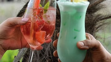Zwei Cocktails in Gläsern, einer mit Erdbeere und Minze garniert, der andere mit Ananasstück und Minze.