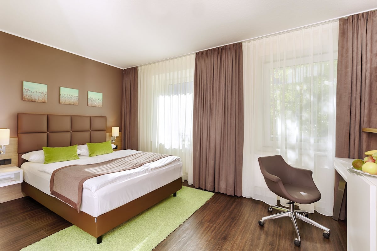 Ein Hotelzimmer mit Bett, Schreibtisch und Stuhl.