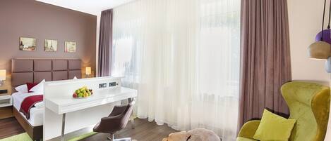 A modern hotel room with a bed, a desk, a chair, and a large window with curtains.