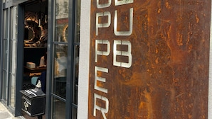 A building with a large, rusted sign reading "SC34" and "SUPPORT" vertically.