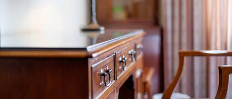 A wooden dresser with drawers and a lamp on top.