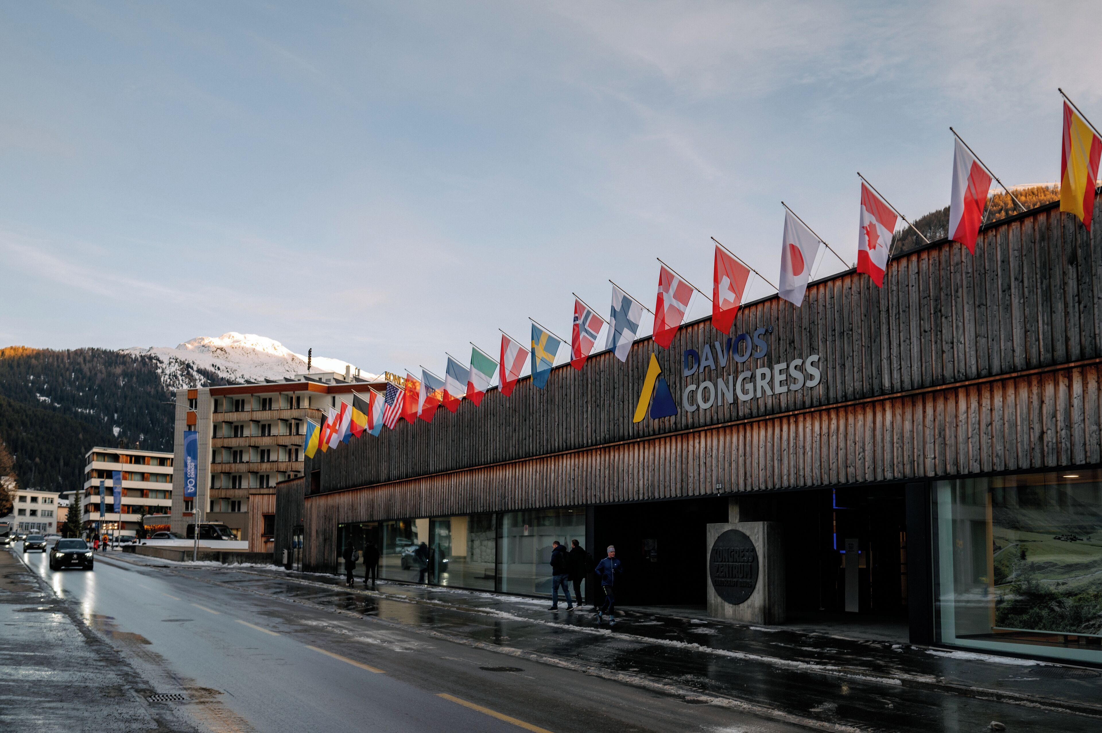 A building with multiple flags, a wooden facade, and a sign that reads "CAVOS CONGRESS".