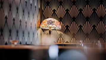 A room with a patterned wall and a stained glass lamp.