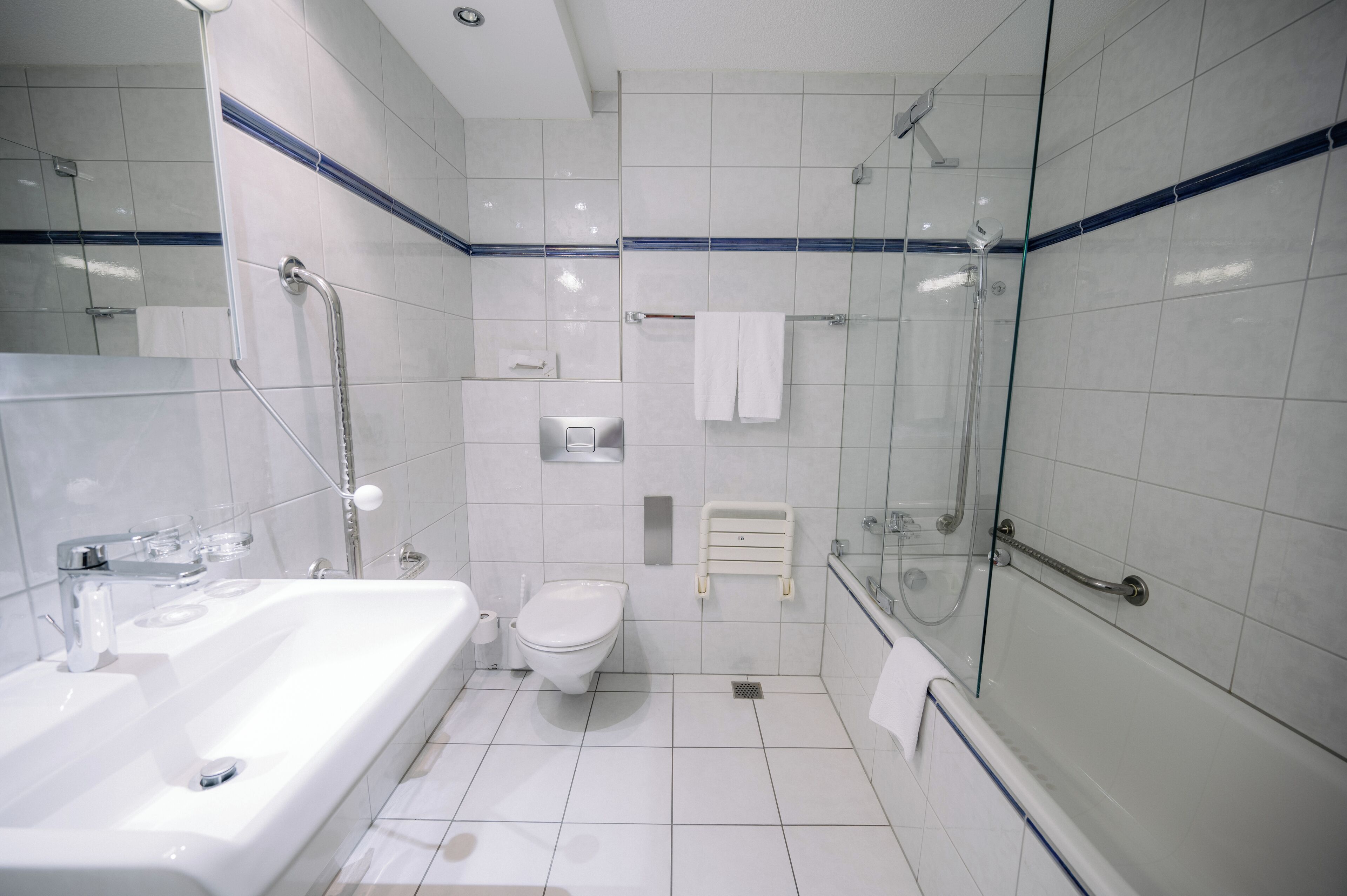 Een moderne badkamer met bad, toilet en douchecabine.