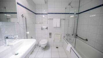 Een moderne badkamer met bad, toilet en douchecabine.