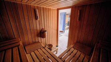 Un sauna en bois avec des bancs et un seau en bois.
