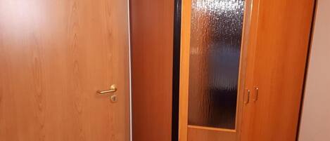 A wooden door with a frosted glass panel and a brass handle.