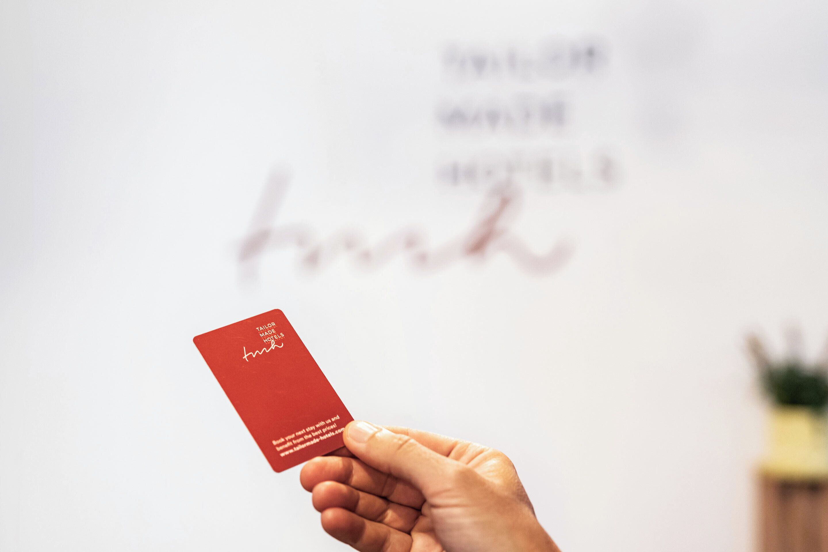Una mano sosteniendo una tarjeta roja con texto.