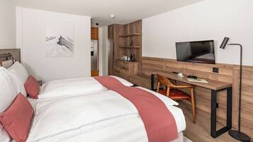 Un dormitorio moderno con cama, escritorio, silla, televisor y armario.