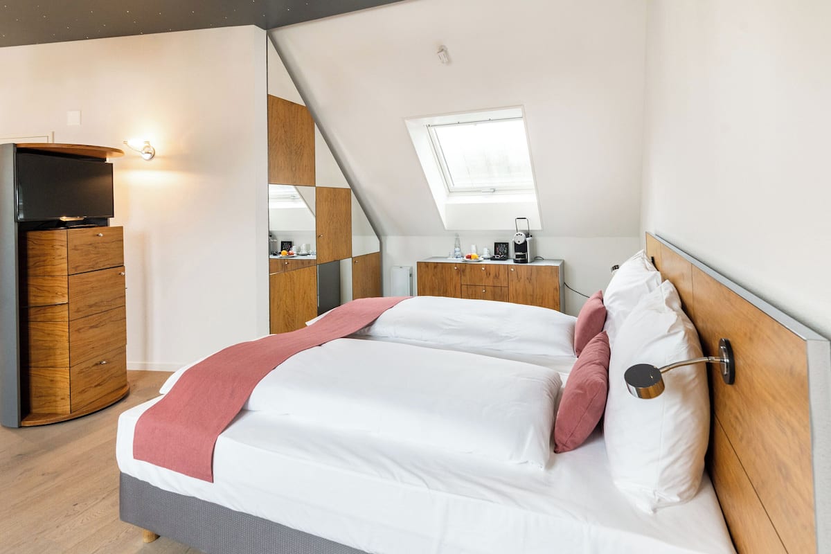 Une chambre à coucher avec un lit, une télévision, un bureau et une fenêtre.