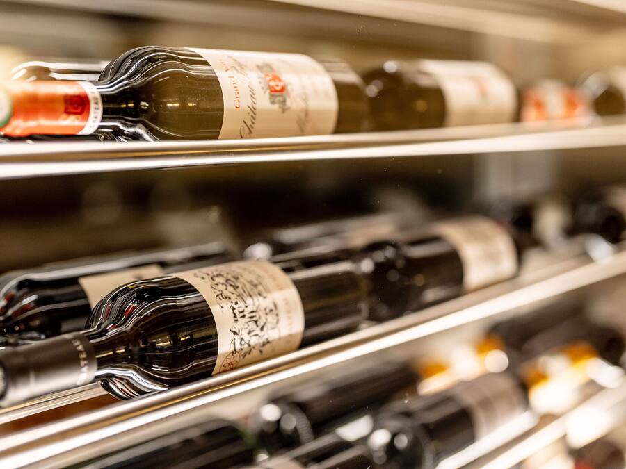 Filetta di bottiglie di vino sugli scaffali.