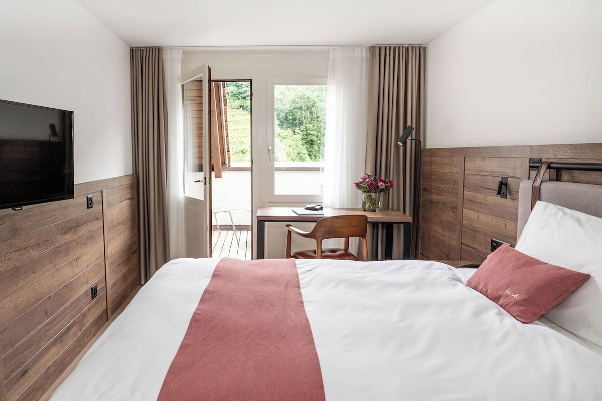 Une chambre d’hôtel avec un lit, une télévision, un bureau et une chaise.