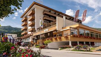 A hotel with multiple balconies, a sign reading "SUNSTAR," and flags.