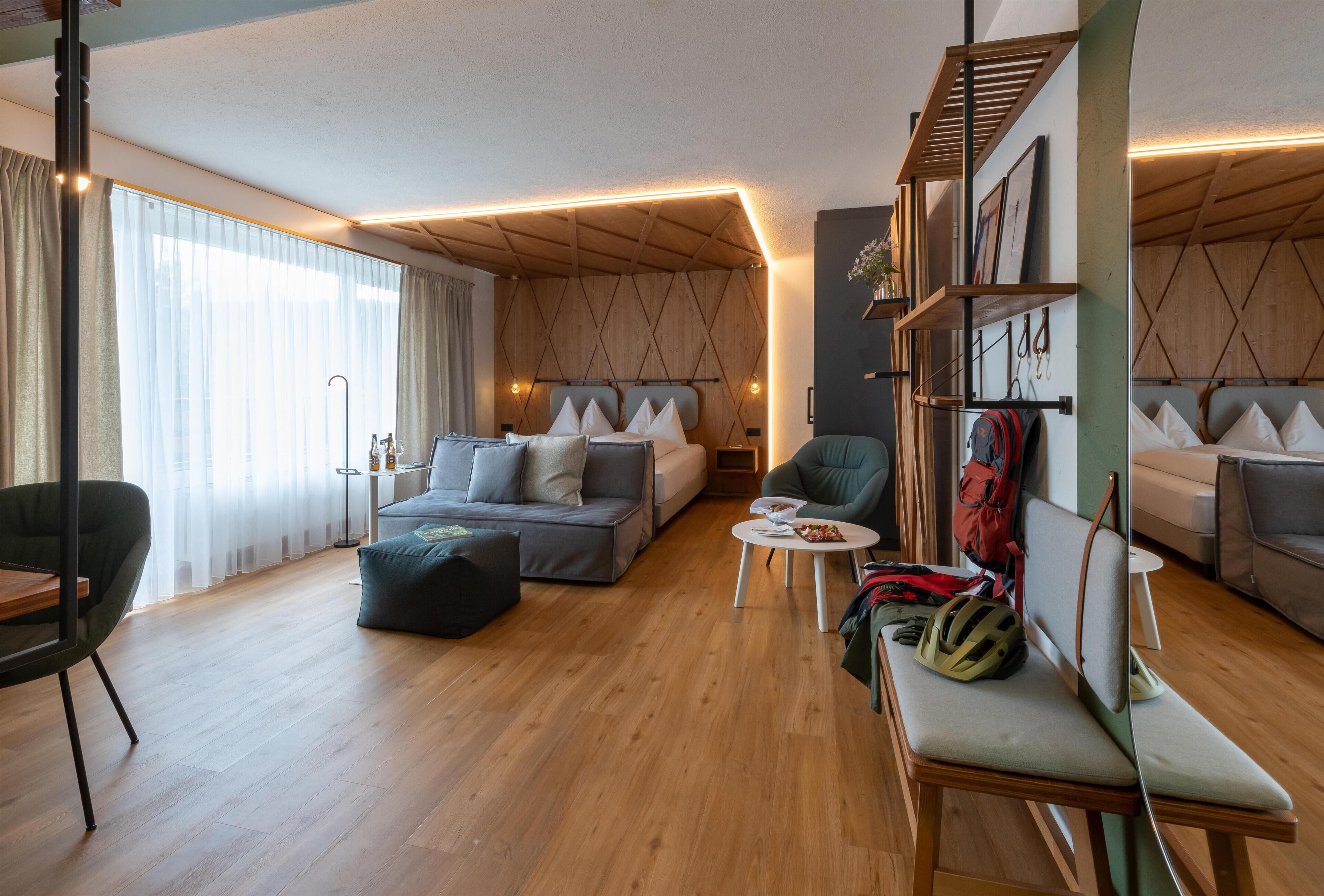 A modern living room with a sofa, armchairs, a coffee table, and a bookshelf.