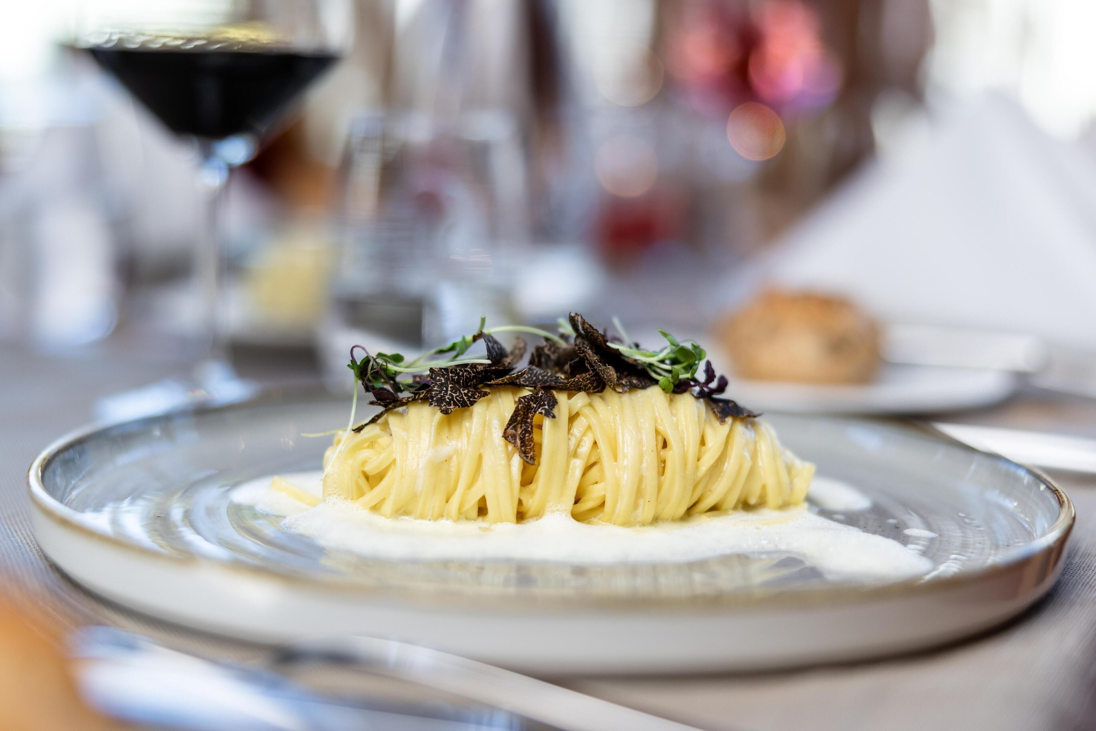 En tallrik pasta med en krämig sås och garnering, serverad på en keramiktallrik.