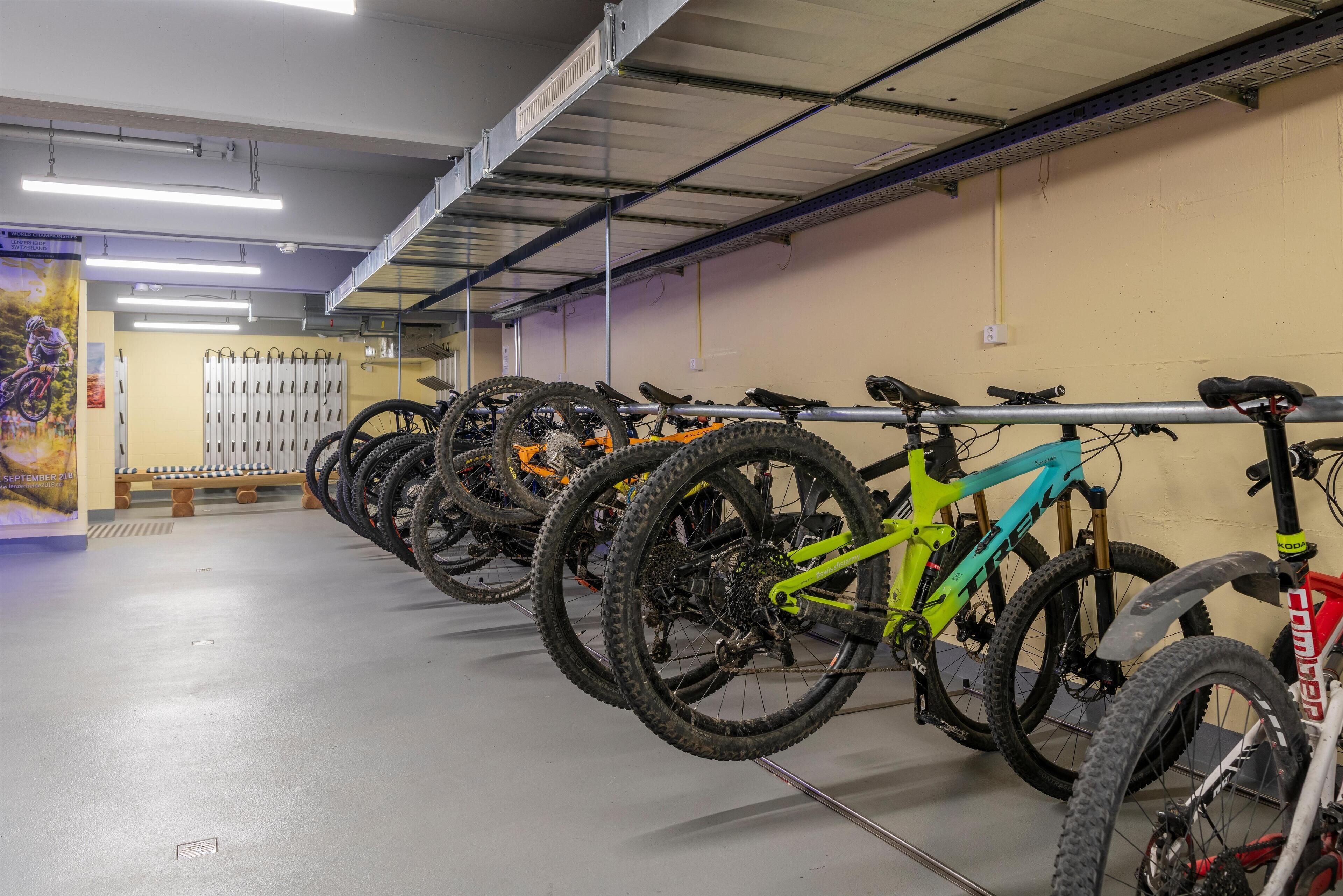 A bike parking area with multiple bicycles and a wall-mounted rack.