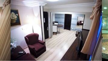 Relax in a stylish room with a large bed, seating area, and modern bathroom featuring a bathtub.