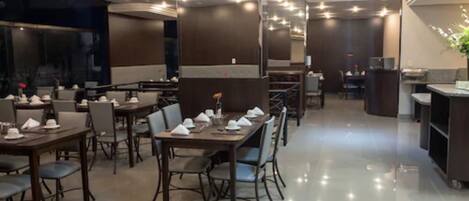 A modern restaurant with neatly arranged tables and chairs, a clean and polished floor, and a well-lit interior.