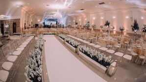 A spacious banquet hall with rows of tables and chairs, a central stage, and elegant chandeliers. - Hotel Lang Palace (Chapecó)